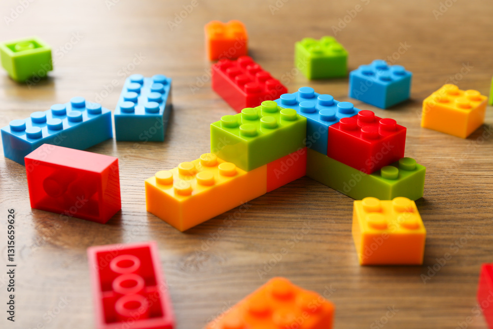 Construction toy. Colorful building bricks on wooden table, closeup