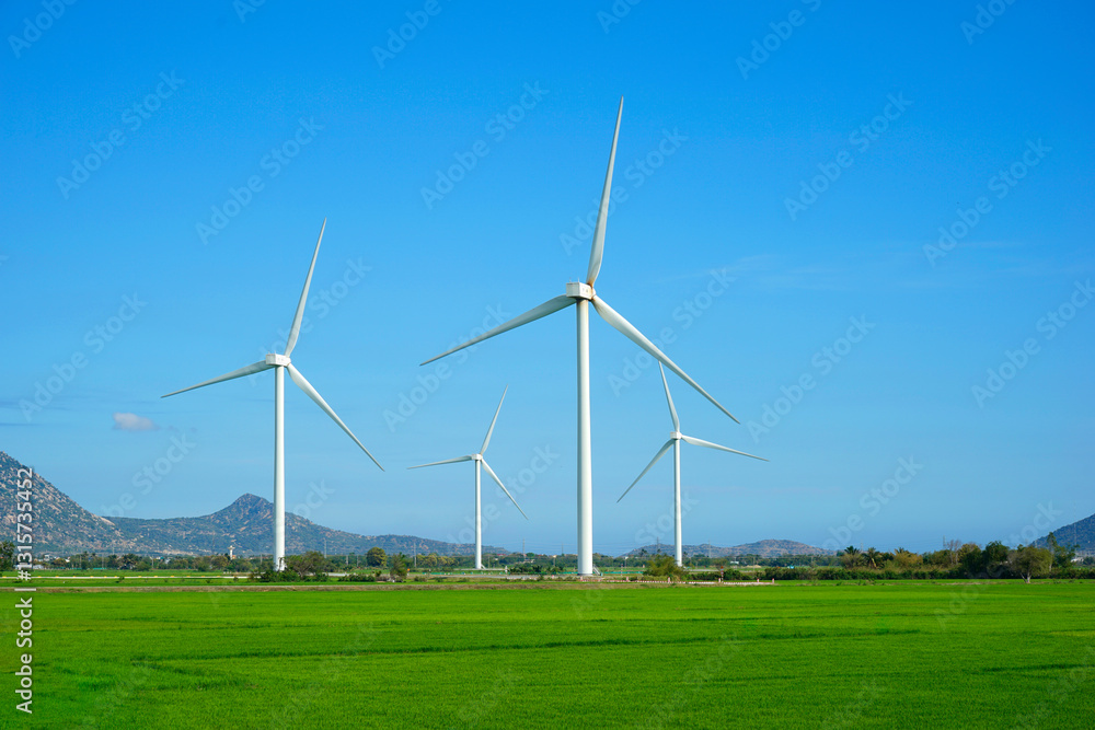 Windmill for electric power production. Wind turbines generating electricity on rice field at Phan Rang, Ninh Thuan, Vietnam. Clean energy concept. Windmill for electric power production. Wind turbines generating electricity on rice field at Phan Rang, Ninh Thuan, Vietnam. Clean energy concept.