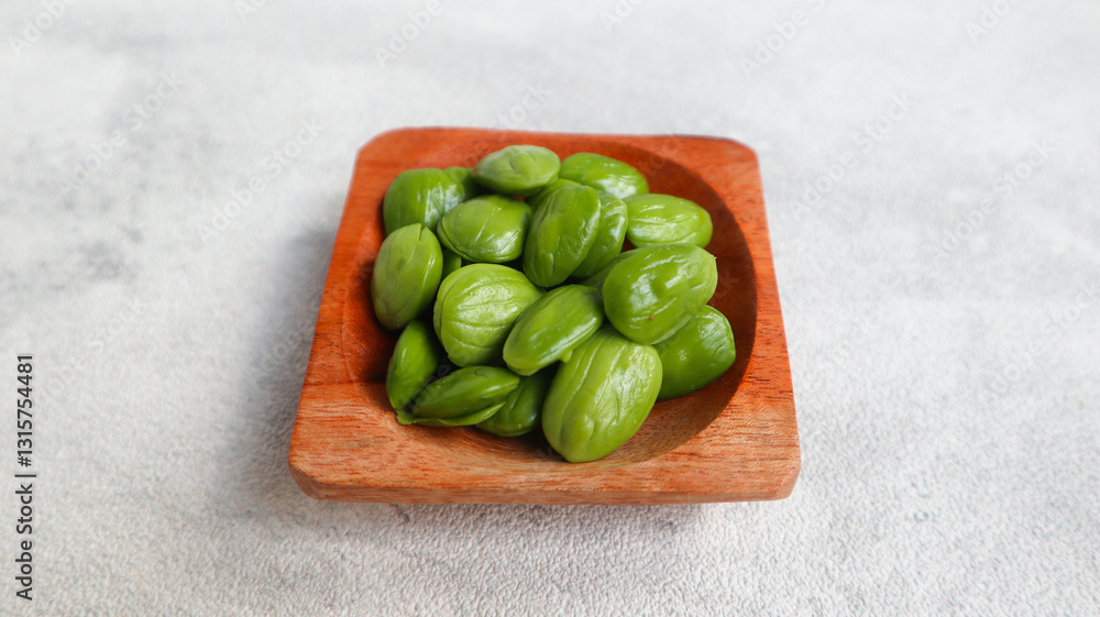 Raw Pete or Petai ,Popular Stinky Bitter Bean on wooden bowl isolated on grey Raw Pete or Petai ,Popular Stinky Bitter Bean on wooden bowl isolated on grey