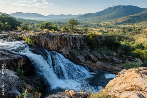 Waterfall cascades down rocky terrain in a green landscape