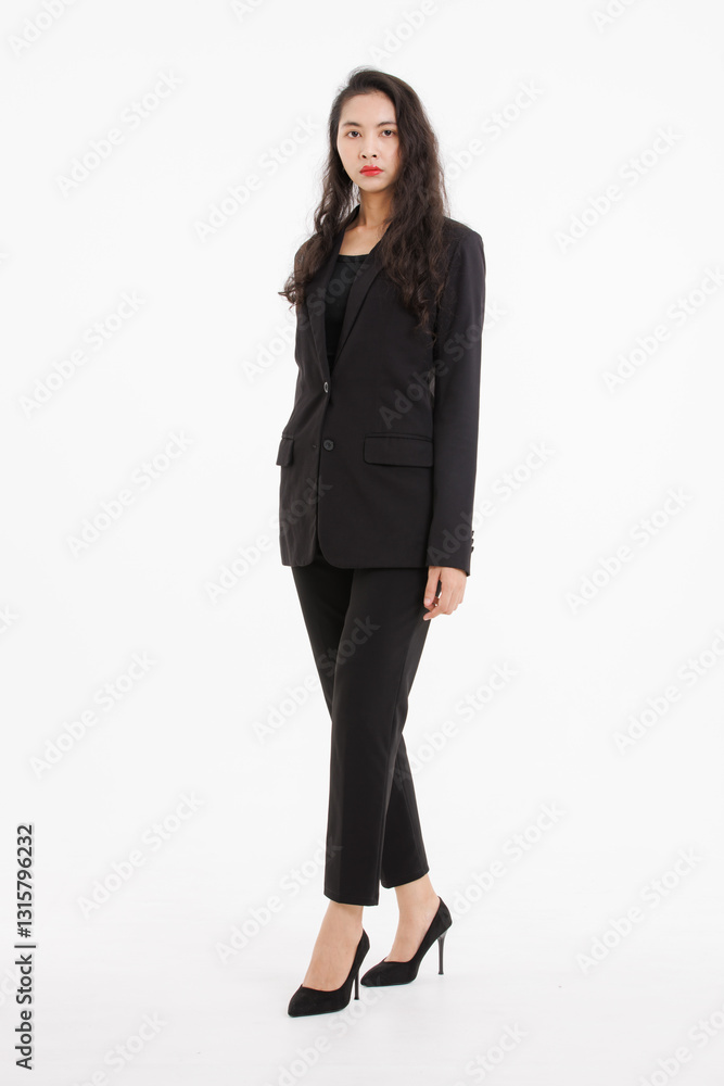 Portrait full body of asian beautiful woman curly long hair, wearing black suit, black long pants, model girl attractive confident charming, standing pose look at camera on white background in studio. Portrait full body of asian beautiful woman curly long hair, wearing black suit, black long pants, model girl attractive confident charming, standing pose look at camera on white background in studio.