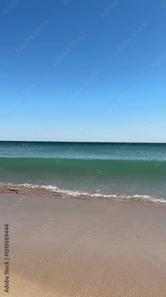 calm water, waves on shoreline, sandy beach landscape against clear blue sky on a sunny summer day calm water, waves on shoreline, sandy beach landscape against clear blue sky on a sunny summer day