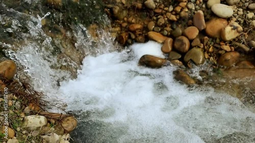 Crystal-clear water flowing over stones in mesmerizing slow-motion detail