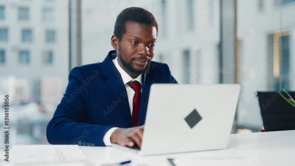 African American businessman working with laptop in modern office, portrait. Busy manager examining documents in computer, black male office worker looking at pc display, financial analyst in office African American businessman working with laptop in modern office, portrait. Busy manager examining documents in computer, black male office worker looking at pc display, financial analyst in office