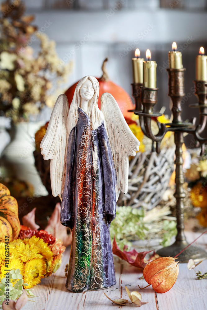 An autumn table decoration with an angel figure in the center, surrounded by many different plants.
