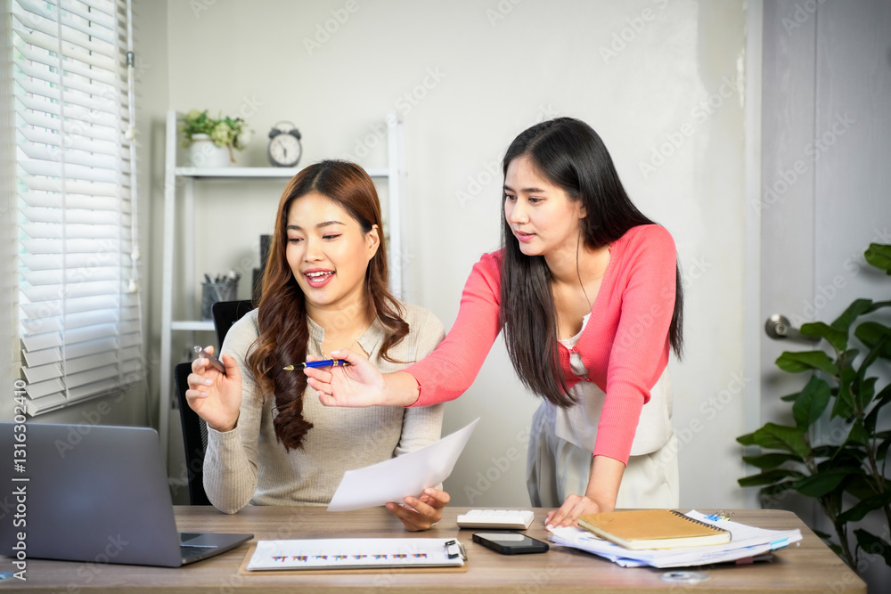 Business team of two executives working together using laptop in office. Happy young business woman manager showing project presentation to mature woman client, investor or partner at work meeting. Business team of two executives working together using laptop in office. Happy young business woman manager showing project presentation to mature woman client, investor or partner at work meeting.