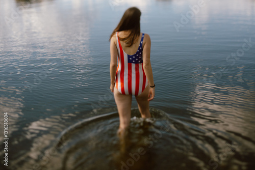 Woman in patriotic swimsuit wading into Sylvan Lake, SD.
