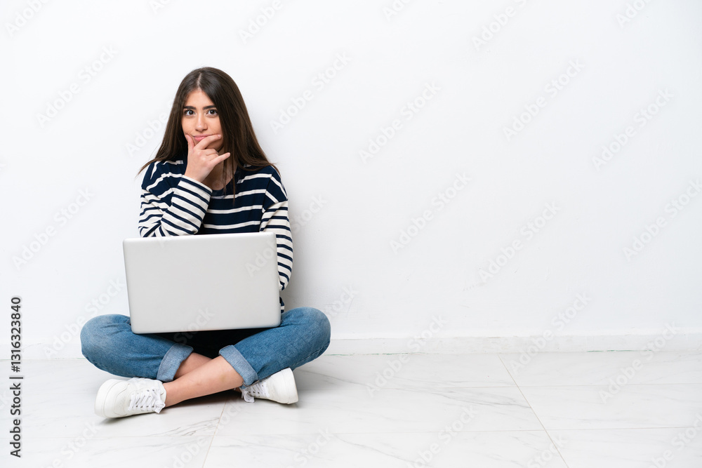 Young caucasian woman with a laptop sitting on the floor isolated on white background surprised and shocked while looking right Young caucasian woman with a laptop sitting on the floor isolated on white background surprised and shocked while looking right