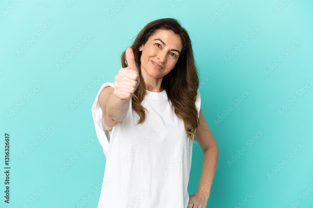 Middle aged caucasian woman isolated on blue background with thumbs up because something good has happened Middle aged caucasian woman isolated on blue background with thumbs up because something good has happened