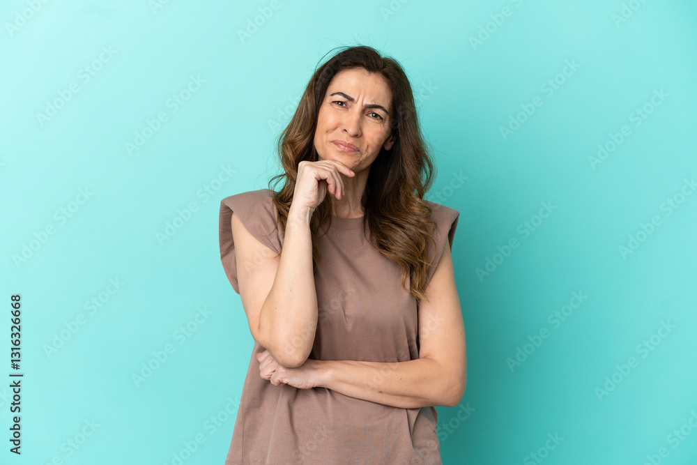 Middle aged caucasian woman isolated on blue background having doubts and thinking Middle aged caucasian woman isolated on blue background having doubts and thinking