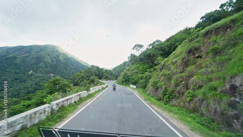 A video shows a tourist riding a racing motorbike, overtaking vehicles on a winding mountain road