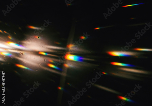Abstract light leak effect with scattered streaks and flares of rainbow light burst, grainy textured across on  black background