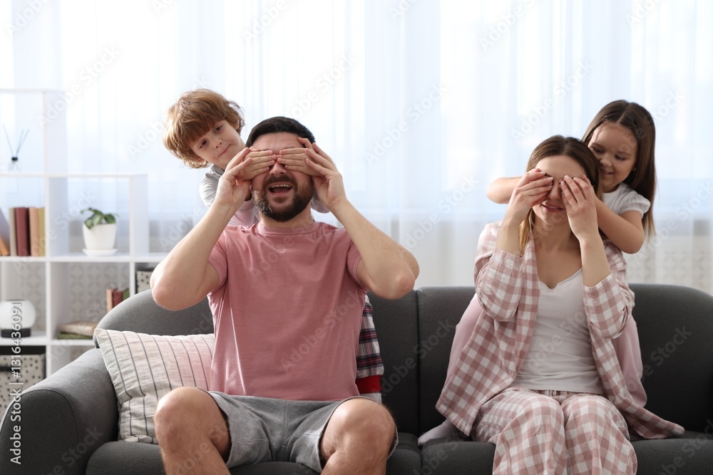 Happy family wearing stylish pajamas having fun on sofa at home Happy family wearing stylish pajamas having fun on sofa at home
