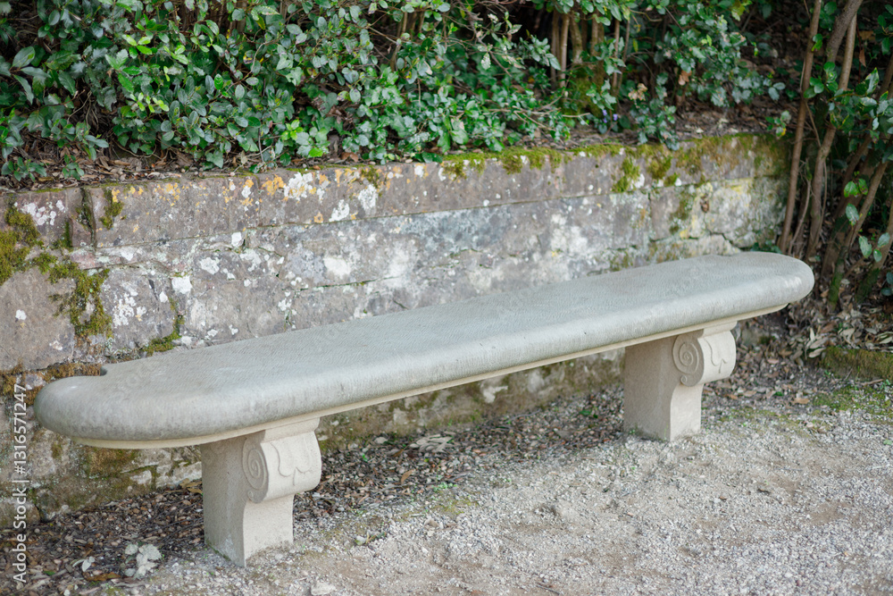Gray relaxing bench in the green garden during summer. Old stone bench in the park, relax time