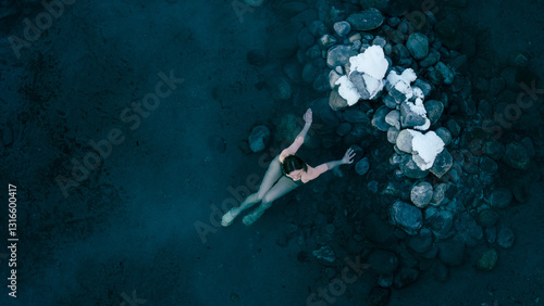 Foto Aerial view of a lone woman relaxing in a stunning thermal spring surrounded by snowy landscapes in Northern Buryatia