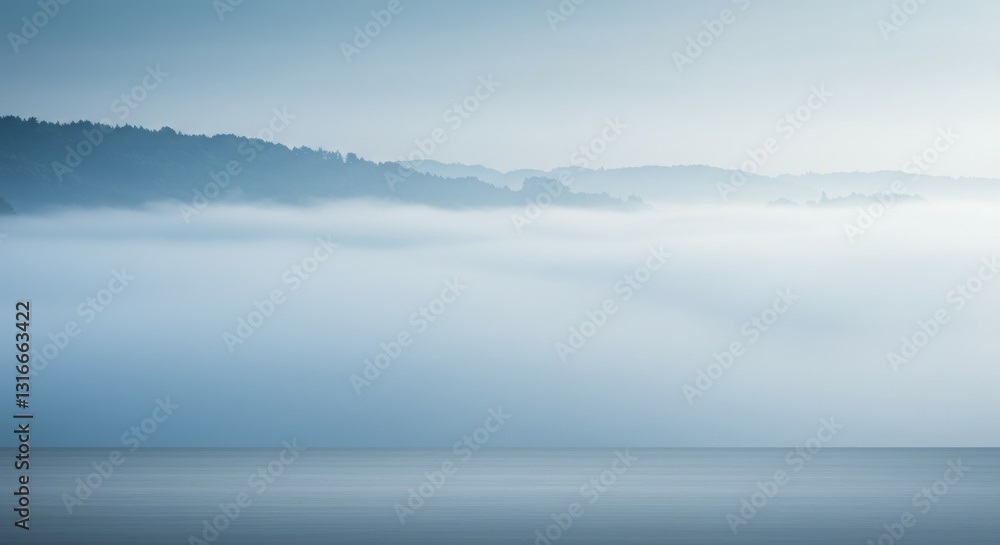 Fototapeta premium A serene landscape of misty hills blending into a calm water surface.