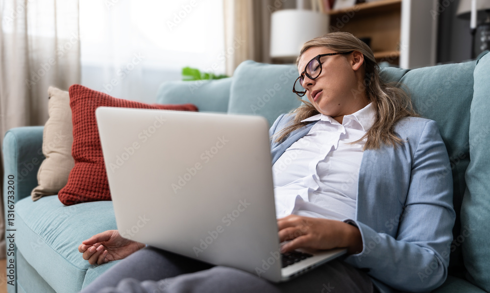 Fototapeta premium Overworked tired businesswoman sleeping on sofa in home office. Young exhausted girl working from home. Woman using laptop. Entrepreneur, freelance work, female sleep after stressed online meeting.