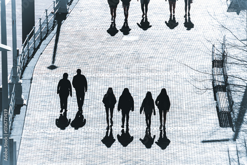 silhouettes and shadows of people walking through the streets of Bilbao