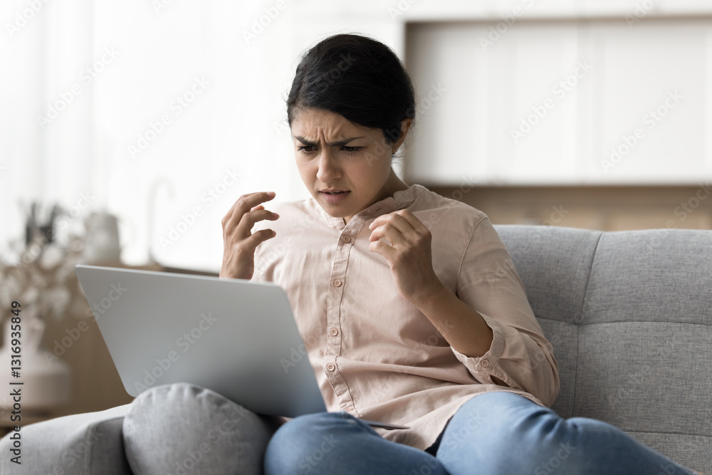 Problem with computer. Annoyed stressed young girl sitting on couch with notebook feel anger anxiety getting slow internet poor bad signal failed wifi connection receiving fraud spam in email message Problem with computer. Annoyed stressed young girl sitting on couch with notebook feel anger anxiety getting slow internet poor bad signal failed wifi connection receiving fraud spam in email message