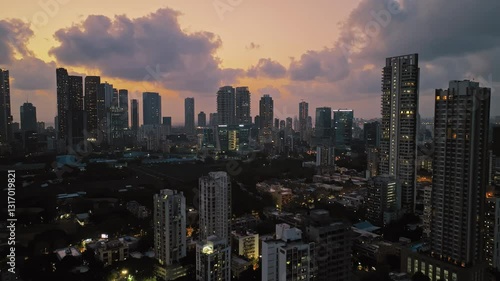 Wallpaper Mural An aerial view of Mumbai's high-rise buildings and beautiful nightlights. The sky is cloudy, and there is medium traffic on the road. The cityscape is filled with modern illuminated buildings. Torontodigital.ca