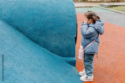 Obraz na plátne Small Chinese girl playing hide and seek at a local playground