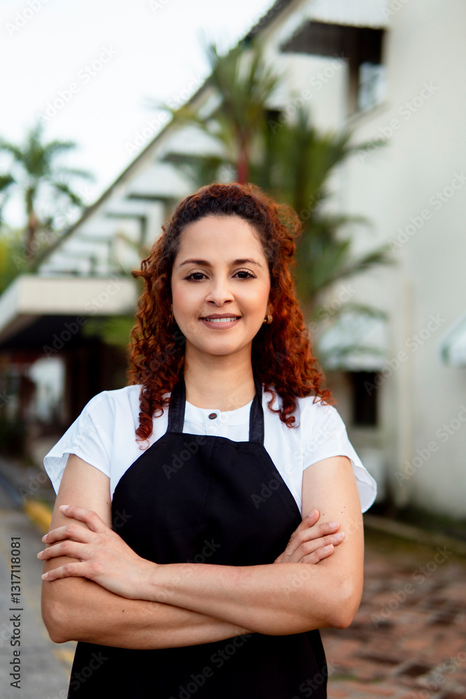 Confident hispanic businesswoman smiling with arms crossed in front of her business Confident hispanic businesswoman smiling with arms crossed in front of her business