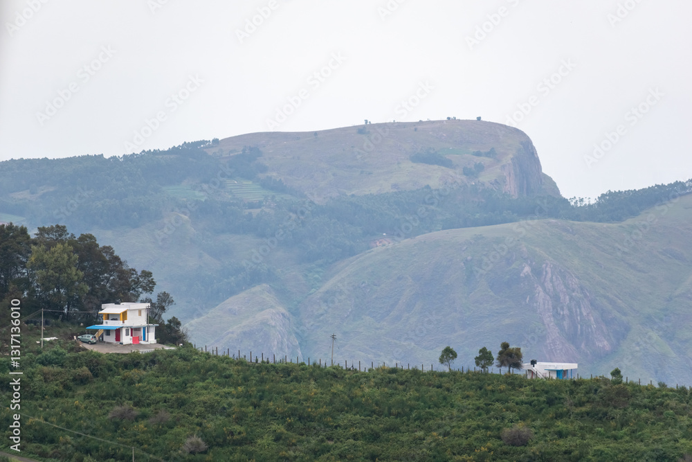 Φωτογραφία Scenic view of rolling hills and quaint homes in Kodaikanal on a misty day surro
