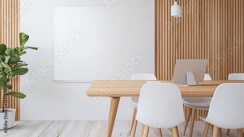 Modern Minimalist Office Space with Wooden Table, White Chairs, Plant, and Blank Canvas Wall