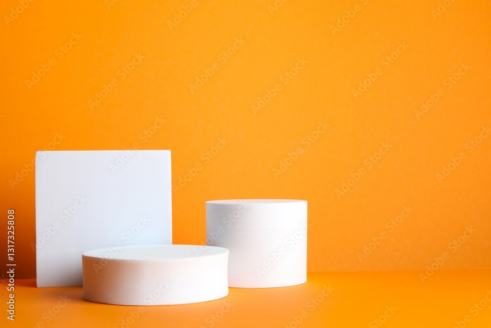 White podiums with pumpkin on orange background White podiums with pumpkin on orange background