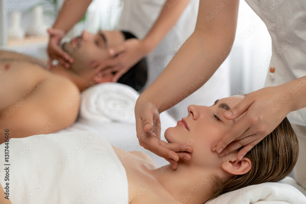 Obraz premium Caucasian couple enjoying relaxing anti-stress head massage and pampering facial beauty skin recreation leisure in dayspa modern light ambient at luxury resort or hotel spa salon. Quiescent