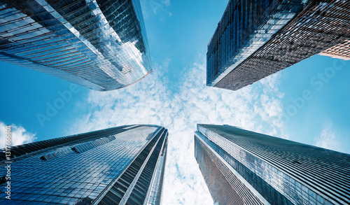 View of high rise glass office building. Royalty high-quality free best stock of looking Up modern high-rise office buildings with blue sky in the background, Bottom up view reflective skyscraper mode