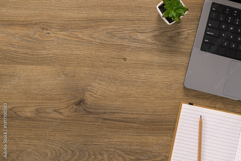 Top view of a wooden office desk with a laptop and notebook. A minimal and modern workspace setup with copy space
