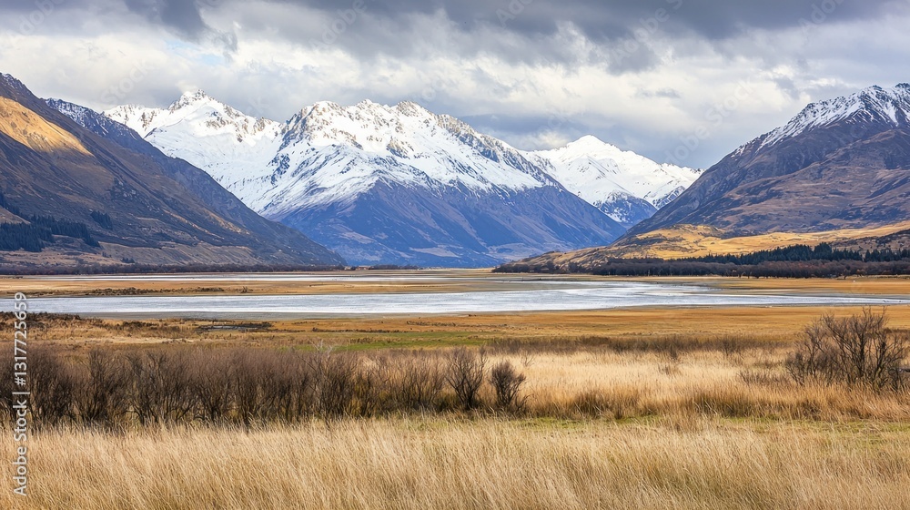 Scenic lake view with snow-capped mountains and autumnal grasslands under a dramatic sky. Scenic lake view with snow-capped mountains and autumnal grasslands under a dramatic sky.