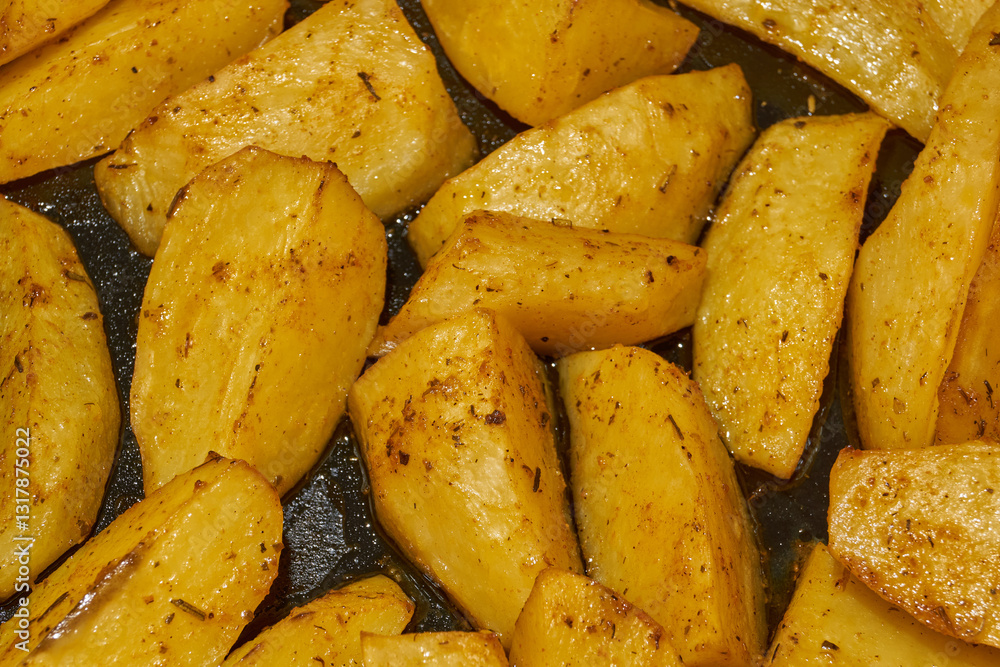 Baked potato slices with seasoning mixture. Close-up. Baked potato slices with seasoning mixture. Close-up.