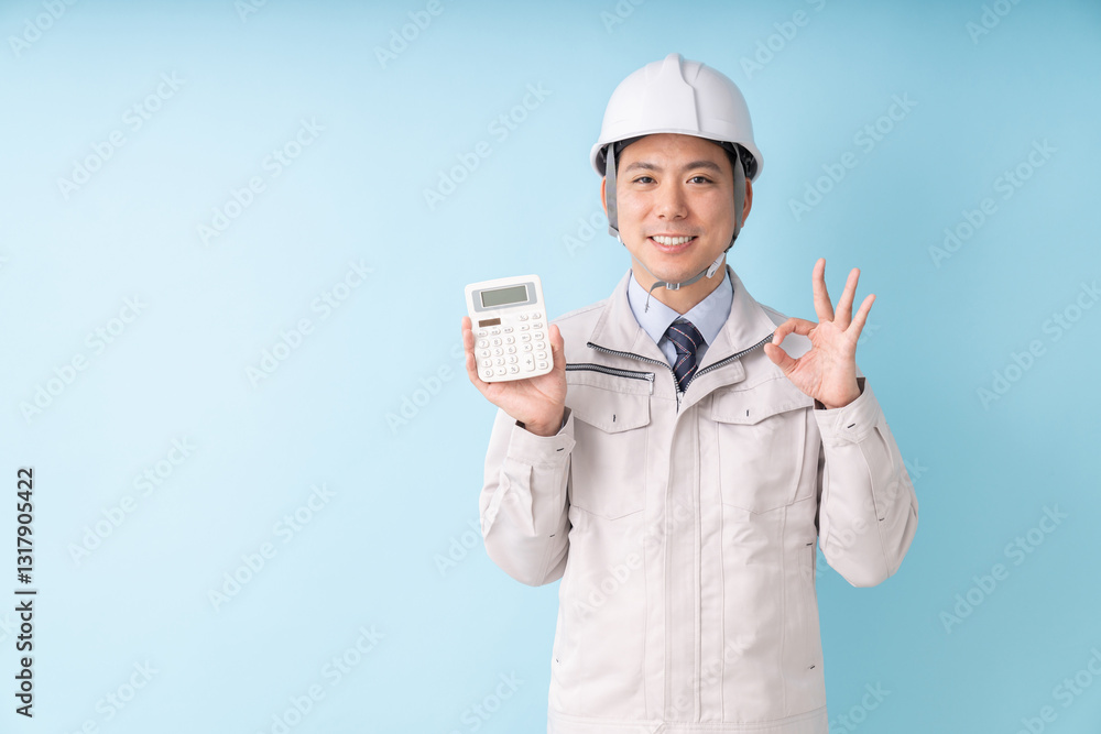 電卓を持つ笑顔の男性　ビジネス　作業服