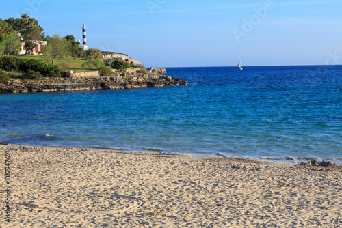 Obraz na płótnie Europe, Spain, Balearic Islands, Mallorca. Porto Colom. lighthouse, children play on beach. 2017-04-16 w salonie