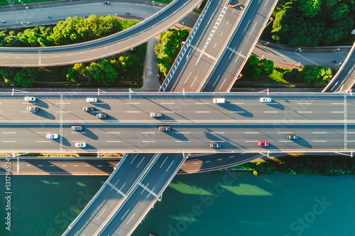 Aerial of vehicles navigate a complex highway system, showcasing overpasses and intersections.