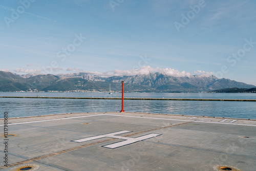 Bild auf Leinwand Helipad on the pier with a signal beacon by the sea against the backdrop of the
