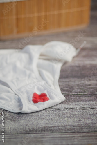 White underwear with period stain on wooden table