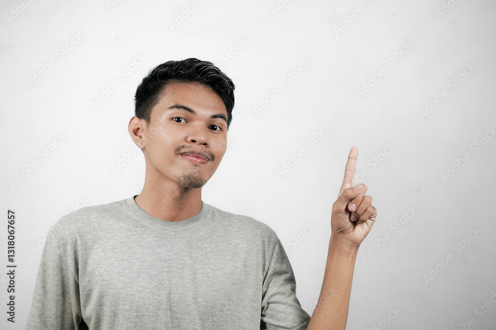 Happy smiling asian man pointing towards top left, product promotion concept, young man isolated on white background Happy smiling asian man pointing towards top left, product promotion concept, young man isolated on white background