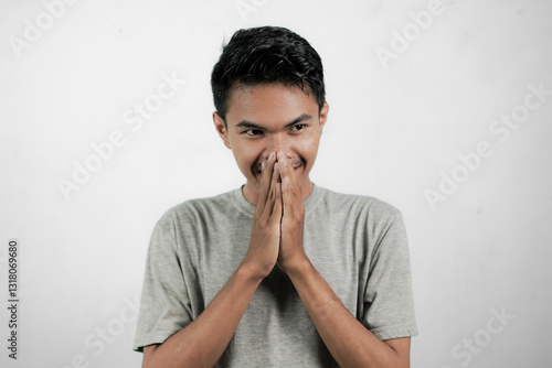 Asian man cupping both hands on mouth, showing smiling expression and finding good plan