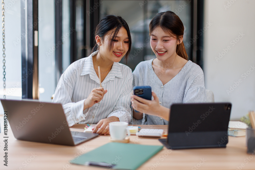 Two happy business asian women coworking with a laptop in a desktop at office
Two happy business asian women coworking with a laptop in a desktop at office