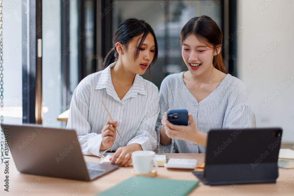 Two happy business asian women coworking with a laptop in a desktop at office
Two happy business asian women coworking with a laptop in a desktop at office