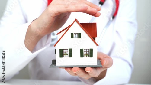 Wallpaper Mural The doctor holds a model of a house in his hands. health concept Torontodigital.ca