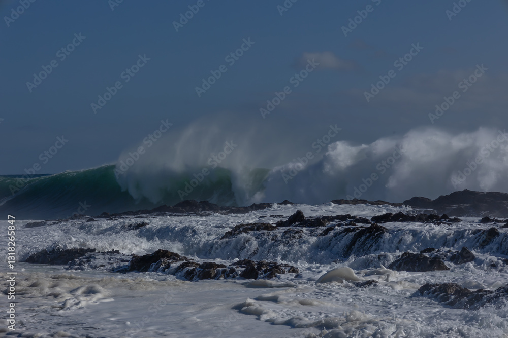 Obraz premium A huge wave driven by an approaching cyclone or hurricane, breaks and crashes wildly into the boiling storm surf, trailing wind blown spray as it breaks at Snapper Rocks on the Gold Coast, Australia.