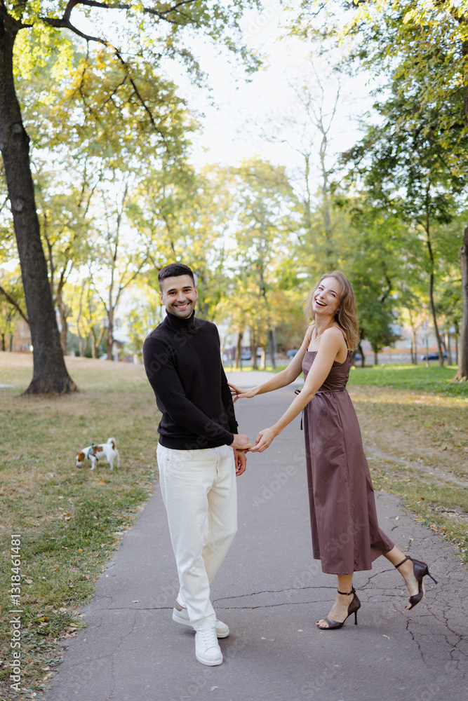 Obraz premium Couple Enjoying a Playful Moment in the Park With a Dog on a Sunny Day