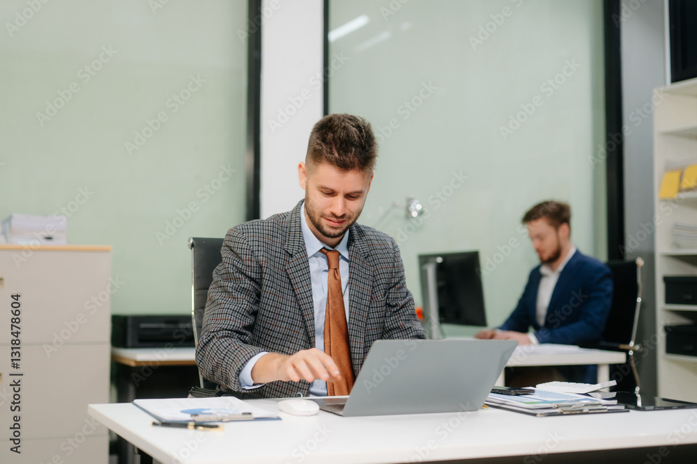 Confident businessman working on finance analysis with a tablet and laptop at office desk Confident businessman working on finance analysis with a tablet and laptop at office desk