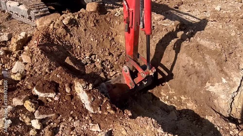 Bandage of a small excavator working and moving rubble on a construction site