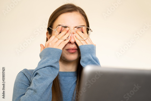 Overworked woman rubbing eyes due to dryness fatigue feeling headache having eyesight problems after computer work. Prolonged screen time digital eye strain sensitivity to light digital addiction.
