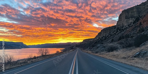 A captivating close-up of a sleek, black road gently veers right, with a striking white stripe dividing its path under an open sky
